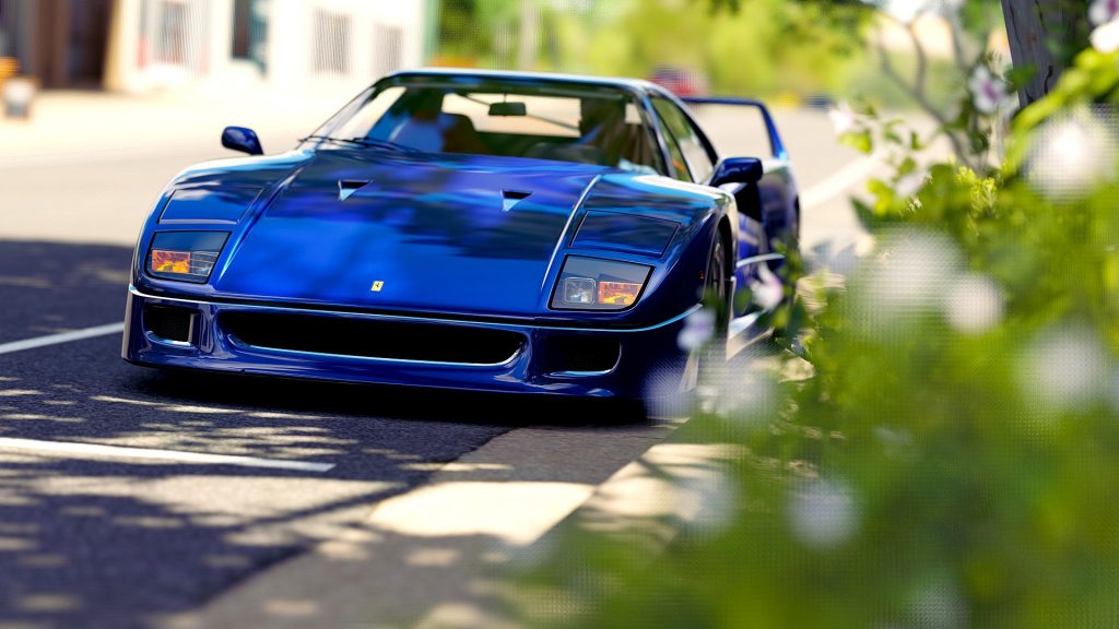 A blue car driving down a street